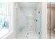 Stylish tiled shower features glass doors and a built-in seat with a sunny window at 1604 Ruskin Way, Marietta, GA 30062