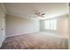 Spacious carpeted bedroom with ceiling fan and a view of trees through the window at 1612 Ruskin Way, Marietta, GA 30062