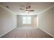 Bright, carpeted bedroom with ceiling fan and a view of trees through the window at 1612 Ruskin Way, Marietta, GA 30062