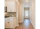 Hallway view of modern kitchen with white cabinets, light countertops, and wood floors at 1612 Ruskin Way, Marietta, GA 30062