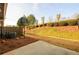 Private backyard featuring a basketball hoop, small patio, and a grassy slope with manicured shrubs at 1670 Granville Ct, Lawrenceville, GA 30043