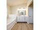 Bright bathroom with double vanity, modern lighting, and a soaking tub at 1670 Granville Ct, Lawrenceville, GA 30043