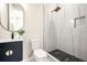 Modern bathroom showcasing a vanity with oval mirror, toilet, and walk-in shower with luxurious marble-like tiling at 237 Altoona Sw Pl, Atlanta, GA 30314