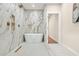 Luxurious bathroom showcasing a freestanding tub, marble-tiled walls, and gold fixtures at 237 Altoona Sw Pl, Atlanta, GA 30314
