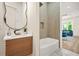 Contemporary bathroom features a modern vanity, oval mirror, and a built-in tub shower with a tiled alcove at 237 Altoona Sw Pl, Atlanta, GA 30314