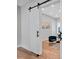 Stylish bedroom featuring a sliding barn door, sleek flooring, and cozy seating area bathed in natural light at 237 Altoona Sw Pl, Atlanta, GA 30314