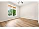 Bright bedroom featuring wood-look floors, a modern ceiling fan, and a large window with natural light and views at 237 Altoona Sw Pl, Atlanta, GA 30314