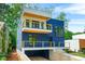 Modern home showcasing a striking blue exterior with a balcony and a well-manicured front yard at 237 Altoona Sw Pl, Atlanta, GA 30314