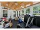 Bright sunroom with wood-paneled ceiling, windows, and ample space for a home gym at 4970 Lakeland Woods Ct, Atlanta, GA 30338