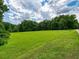 A large lot with cut grass is surrounded by mature trees at 1624 Ruskin Way, Marietta, GA 30062