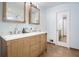 Double sink bathroom vanity with wood cabinets, tiled floor, and large mirrors at 345 Lambeth Dr, Hiram, GA 30141