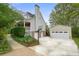 View of the house exterior, showing the garage, lush landscaping, and a basketball hoop at 345 Lambeth Dr, Hiram, GA 30141