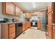 Well-equipped kitchen features stainless steel appliances, warm wood cabinetry, and tile floors at 345 Lambeth Dr, Hiram, GA 30141