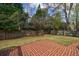 Fenced backyard features a well-manicured lawn and a brick patio for outdoor enjoyment at 5 Coventry Close, Avondale Estates, GA 30002