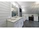 Spacious bathroom with dual sinks, white cabinets, marble countertops, and shiplap walls at 5 Coventry Close, Avondale Estates, GA 30002