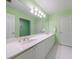 Bathroom featuring double sinks with white cabinets and white tiled flooring at 5 Coventry Close, Avondale Estates, GA 30002