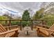 Outdoor wooden deck with seating overlooking a lush backyard and cloudy sky at 5 Coventry Close, Avondale Estates, GA 30002