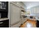 Well-lit kitchen features stainless steel appliances, custom cabinets, and beautiful hardwood floors at 5 Coventry Close, Avondale Estates, GA 30002
