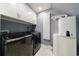 Well-organized laundry room features modern washer and dryer, white cabinets, and a sleek water heater at 5 Coventry Close, Avondale Estates, GA 30002