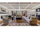 Bright living room featuring hardwood floors, coffered ceilings, a fireplace, and large windows overlooking the backyard at 5 Coventry Close, Avondale Estates, GA 30002