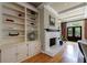 Living room featuring a brick fireplace, custom shelving, hardwood floors, and a door to the backyard at 5 Coventry Close, Avondale Estates, GA 30002