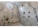 Luxurious marble shower featuring a bench, multiple shower heads, and unique octagon window at 5 Coventry Close, Avondale Estates, GA 30002