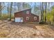 Rear view of home featuring a garage, white doors and wood facade, with trees in background at 279 Alex St, Canton, GA 30114