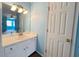 Well-lit bathroom showcasing a white vanity with sink and a large mirror reflecting the adjacent bedroom at 3520 Newberry Ln, Douglasville, GA 30135