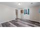 Bedroom features light-colored walls, laminate flooring, and a door leading to the staircase at 6265 Reives Rd, Cumming, GA 30041