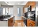 Modern kitchen features stainless steel appliances, black tiled backsplash, and granite countertops with city views at 44 Peachtree Nw Pl # 1328, Atlanta, GA 30309