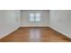 Bright, empty living room featuring hardwood floors, white walls, and a window, ready for customization at 3510 Nw Roswell Nw Rd # J1, Atlanta, GA 30305