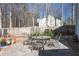 View of the backyard stone patio with table and chairs and a wood fence at 5770 Millstone Dr, Cumming, GA 30028