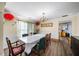 Dining room with hard surface floors, dining table, decorative light fixture, and access to the kitchen at 5770 Millstone Dr, Cumming, GA 30028