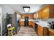 Bright kitchen featuring stainless steel refrigerator and black appliances, wooden cabinetry and modern flooring at 5770 Millstone Dr, Cumming, GA 30028