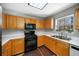 Bright kitchen featuring stainless steel appliances, wooden cabinetry, white countertops and modern flooring at 5770 Millstone Dr, Cumming, GA 30028