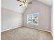 Neutral bedroom featuring vaulted ceiling, ceiling fan, and large window with neighborhood views at 7006 Mahonia Pl, Lithonia, GA 30038