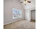 Bedroom featuring vaulted ceiling, neutral carpet, closet, and a window with neighborhood views at 7006 Mahonia Pl, Lithonia, GA 30038