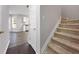 View of a staircase with carpet covering, a front closet, and a glimpse into the living area and kitchen at 7006 Mahonia Pl, Lithonia, GA 30038