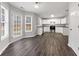 Bright kitchen with stainless steel appliances, white cabinets, and dark wood flooring at 7006 Mahonia Pl, Lithonia, GA 30038