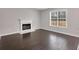 Bright living room featuring a fireplace and large window, hardwood floors at 7006 Mahonia Pl, Lithonia, GA 30038