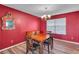 Classic dining room featuring wood floors, vibrant red walls, and an elegant chandelier at 5073 Hyacinth Ln, Austell, GA 30106