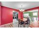 Classic dining room featuring wood floors, vibrant red walls, and an elegant chandelier at 5073 Hyacinth Ln, Austell, GA 30106