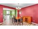 Classic dining room featuring wood floors, vibrant red walls, and an elegant chandelier at 5073 Hyacinth Ln, Austell, GA 30106