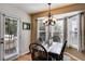 Cozy dining room features a dark wood table set below an elegant chandelier and next to a glass paneled door at 673 Waters Rd, Hiram, GA 30141