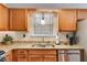 Close-up of kitchen granite countertop with stainless steel appliances, sink, and wooden cabinets at 673 Waters Rd, Hiram, GA 30141