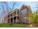 Rear exterior of home featuring large windows, a screened-in porch, and a well-kept lawn at 7640 Harbour Walk, Cumming, GA 30041