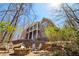 Large backyard with a multi-story home, complete with a stone fire pit, several chairs, and landscaping at 7640 Harbour Walk, Cumming, GA 30041