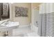 Cozy bathroom featuring a tiled shower-tub, a pedestal sink, and classic fixtures at 7640 Harbour Walk, Cumming, GA 30041