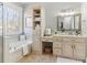 Bright bathroom featuring soaking tub, neutral color palette, and window at 7640 Harbour Walk, Cumming, GA 30041