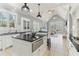 Bright, open kitchen with island, black countertops, white cabinets, and an open view into the living room at 7640 Harbour Walk, Cumming, GA 30041